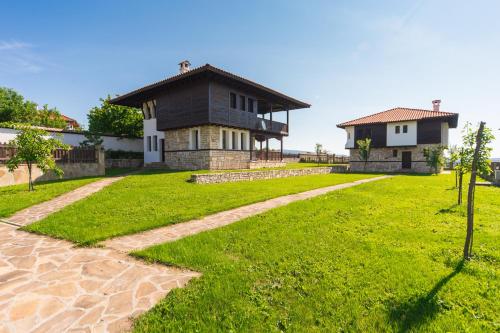 a house with a green lawn and a house at Complex Rayuvski Han in Rayuvtsi