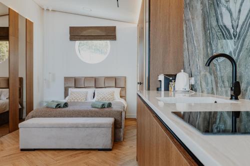 a bedroom with a bed and a kitchen with a sink at Lavyso perlai, 7-8 nameliai in lavysas