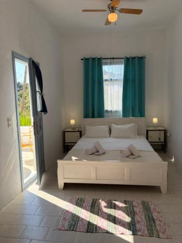 a bedroom with a white bed and a green curtain at White Cat in Vromolithos