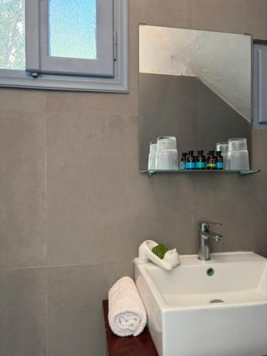 a bathroom with a sink and a mirror at White Cat in Vromolithos