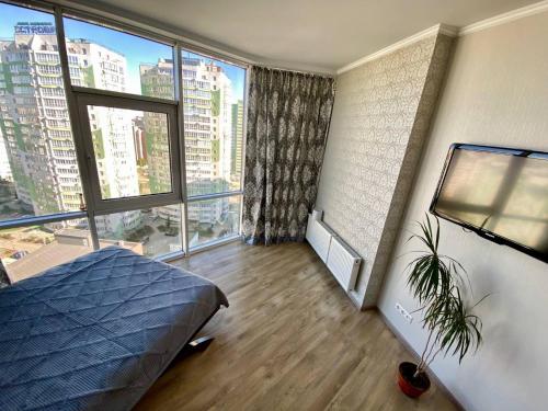 a bedroom with a bed and a large window at Марсельская Residence in Kryzhanivka