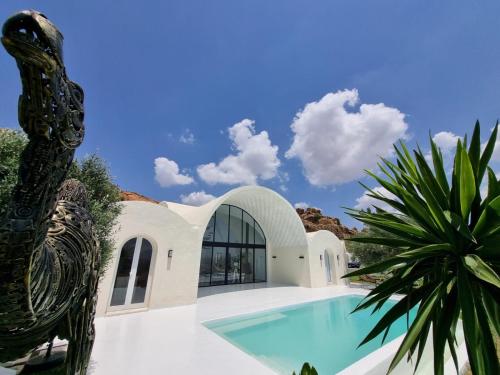 a villa with a swimming pool and a palm tree at Dar El Monchar - Hammamet in Hammamet