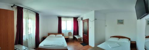 a room with two beds and a couch in it at Casa Maxim in Sulina