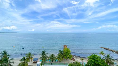 a view of a beach with palm trees and the ocean at Magico Apartamento Frente al Mar 3 Habitaciones TR72 in Guayabal