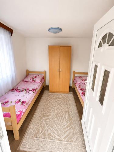 a bedroom with two beds and a cabinet at Cottage near Ostrog in Gornja Povija