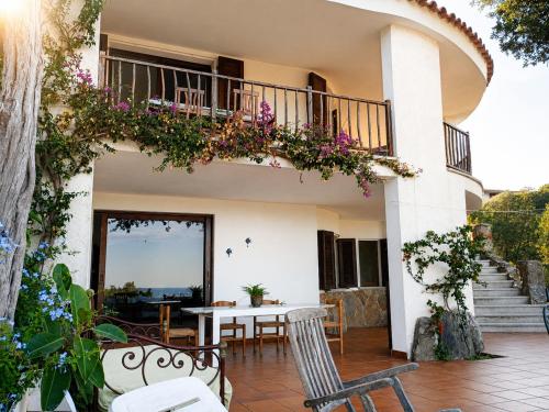 a house with a balcony with a table and chairs at Catalina, ritorno al '70 tra mare e natura in Cannigione