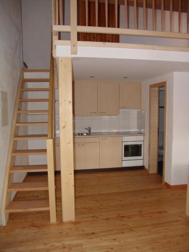 a loft bed in a kitchen with a staircase at Crusch Alba Studio auf der Strassenseite Sta Maria in Sta Maria Val Müstair