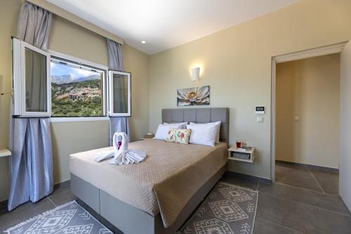 a bedroom with a bed and a large window at Nikos & Vassilis apartments Kefalonia in Vlachata