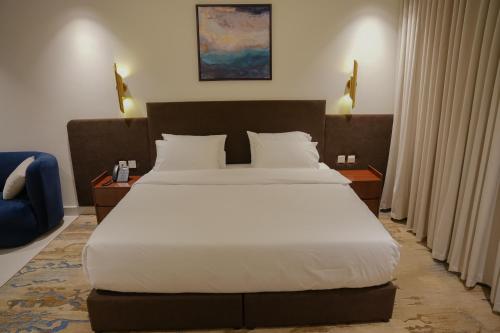 a bedroom with a large bed with white sheets at Sambac hotel in Jeddah