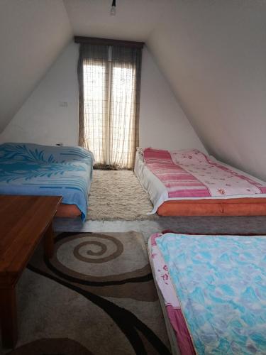a attic room with two beds and a window at Vikendica Peace in Brezje