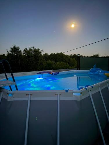 a large swimming pool with a chair in it at Vikendica Peace in Brezje