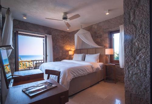 a bedroom with a bed and a view of the ocean at Beyond Villas in Agios Nikitas