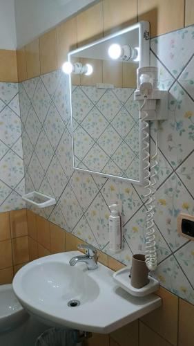 a bathroom with a sink and a blow dryer at Hotel Tre Lanterne in Marina di Sibari