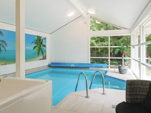 a swimming pool in a house with a large window at 4 star holiday home in Væggerløse in Bøtø By