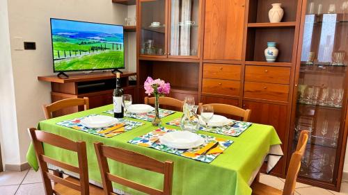 a dining room with a table with a green table cloth at Tuscan Charm Spacious Florence Home in Campi Bisenzio