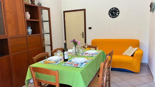 a table with a green table cloth and a yellow chair at Tuscan Charm Spacious Florence Home in Campi Bisenzio