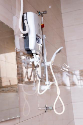 a hair dryer hanging on a wall in a bathroom at M3 Stella Hotel in Kampala