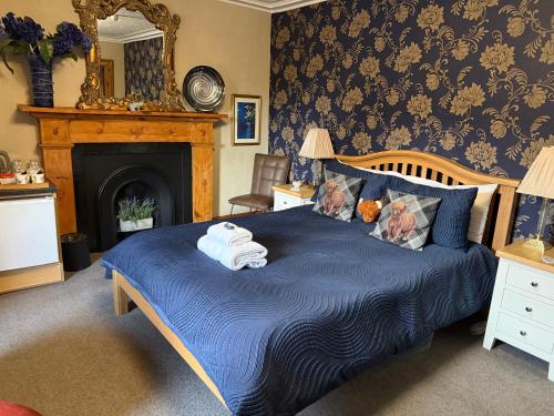 a bedroom with a blue bed with towels on it at Dionard Guest House in Inverness