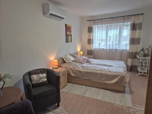 a bedroom with a bed and a chair at La Casa Vendégház in Bogács