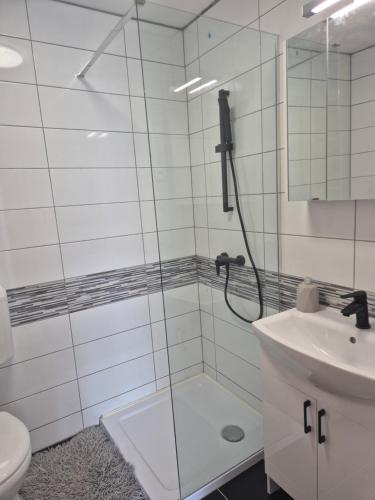 a bathroom with a shower and a toilet and a sink at La Casa Vendégház in Bogács