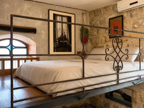 a bedroom with a metal bed in a room at Narkis - A Boutique Stay in the Heart of Jerusalem in Jerusalem