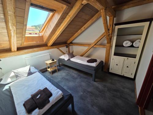 a attic room with two beds and a window at Apartmán U lípy in Semily