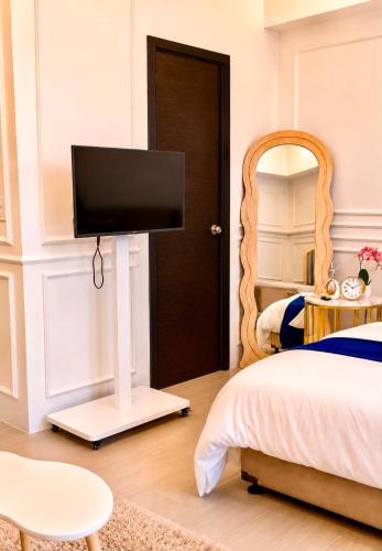 a bedroom with a bed and a flat screen tv at Yssabelle's Homestay in Sampong