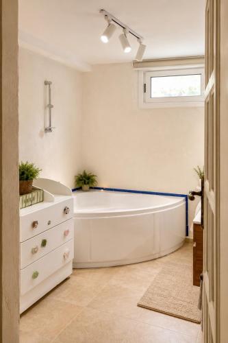 a white bath tub in a bathroom with a window at Villa Bleu Horizon in El Haouach