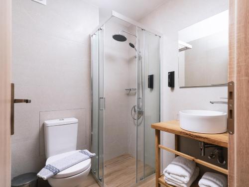 a bathroom with a shower and a toilet and a sink at Matala Bay Hotel in Matala