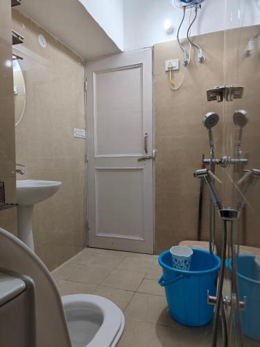 a bathroom with a shower with a toilet and a door at MP Residency Homestay in Munsyari