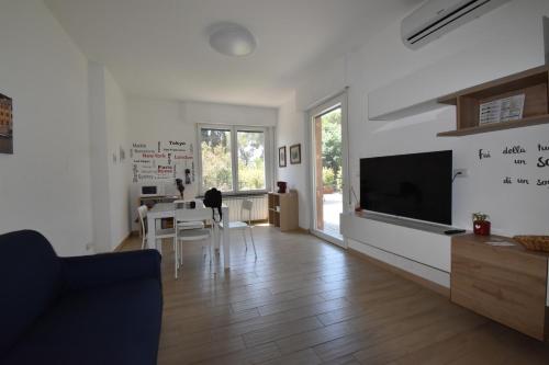 a living room with a table and a tv on a wall at Casa Lorica in Pieve Ligure