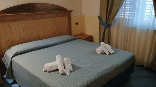 two towels on a bed in a bedroom at Hotel Tre Lanterne in Marina di Sibari