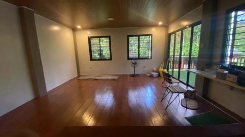 an empty living room with wooden floors and windows at Casa Domingo Guest House in Camalig