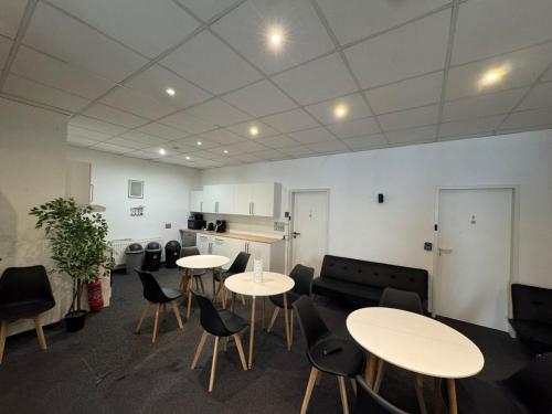 a room with tables and chairs and a kitchen at Zentrales Boardinghouse MG Rheydt in Mönchengladbach