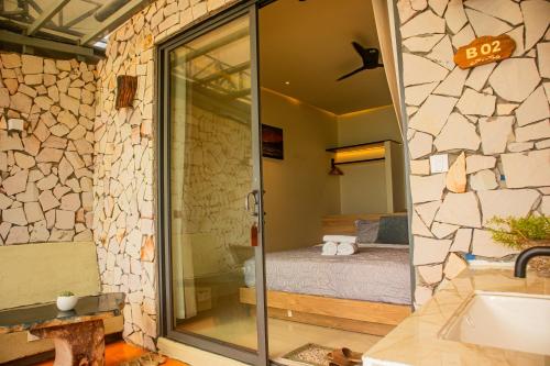 a bathroom with a glass door leading to a bedroom at Chill Beach House in Phú Quốc