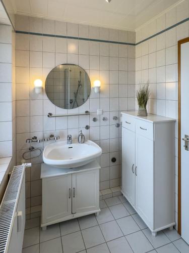 a bathroom with a sink and a mirror at Ferienwohnung *Jessen´s Wattblick* in Wittdün