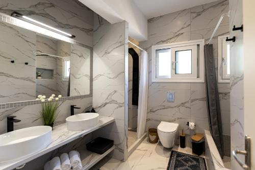 a bathroom with two sinks and a mirror at Nikos & Vassilis apartments Kefalonia in Vlachata
