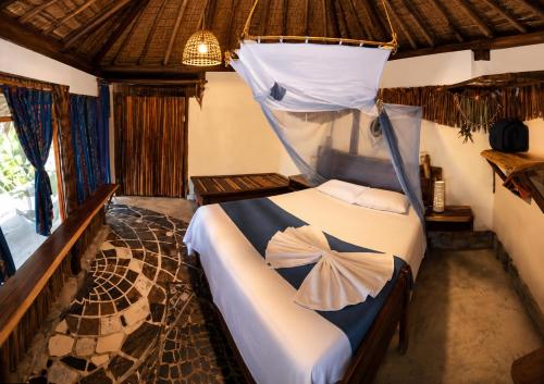 a bedroom with a bed with a mosquito net at Casa Lamat in Bacalar
