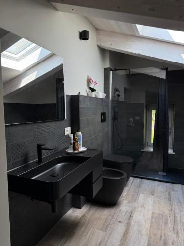 a bathroom with a black sink and a toilet at Dimora Gubbiano in Cascia