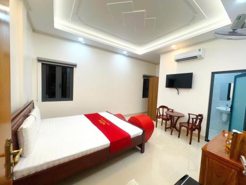 a bedroom with a bed and a table and chairs at Hotel PHƯƠNG MAI 2 in Bến Lức