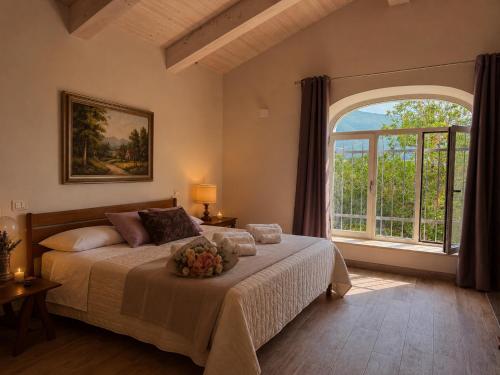 a bedroom with a large bed with a large window at Dimora Gubbiano in Cascia