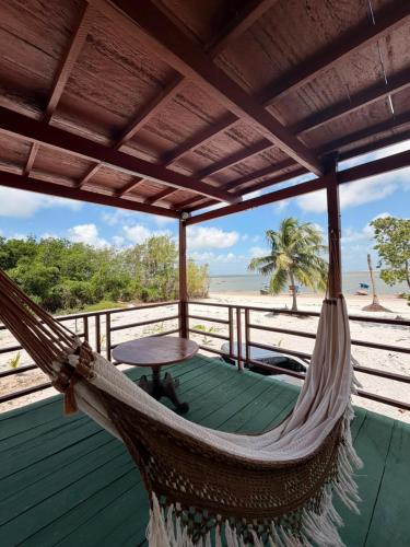 a hammock on a deck with a view of the beach at casa sol in Bragança
