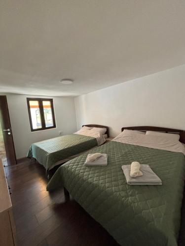 two beds in a room with green sheets and towels at Vila Luminis in Seone