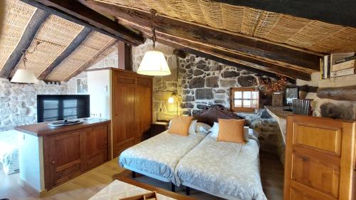 a bedroom with a bed and a stone wall at El Racó de les Grases in Horta de San Joan