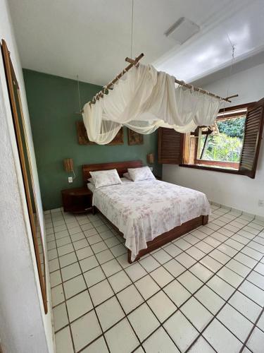 a bedroom with a large bed and a window at Pousada Girassol in Itacaré