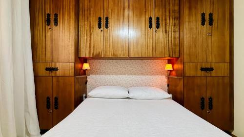 a bedroom with a large bed with wooden cabinets at Recanto Luar Monte Verde in Monte Verde