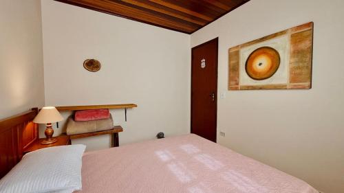 a bedroom with a bed and a painting on the wall at Recanto Luar Monte Verde in Monte Verde