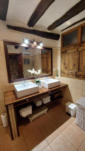 a bathroom with two sinks and a large mirror at El Racó de les Grases in Horta de San Joan