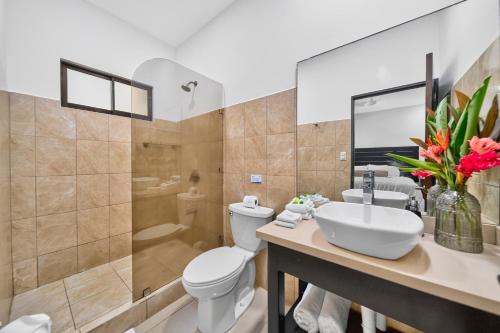 a bathroom with a sink and a toilet and a shower at Buena Vista Plus in Quepos