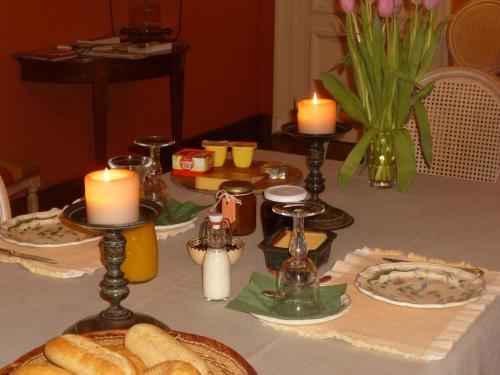 a table with bread and candles on a table at Chambre d'Hôtes Les Augustins - Parking sécurisé - Borne de recharge in Huy